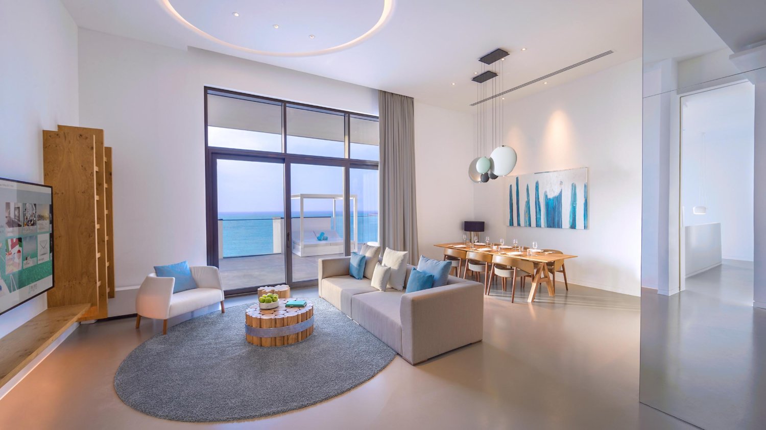 Living room of the ultimate sea view suite showing sofa, arm chair and dining table area