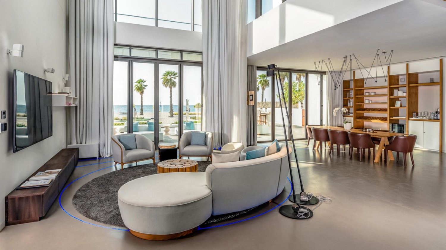 Living room area with arm chairs, sofa, flat screen tive and large dining table