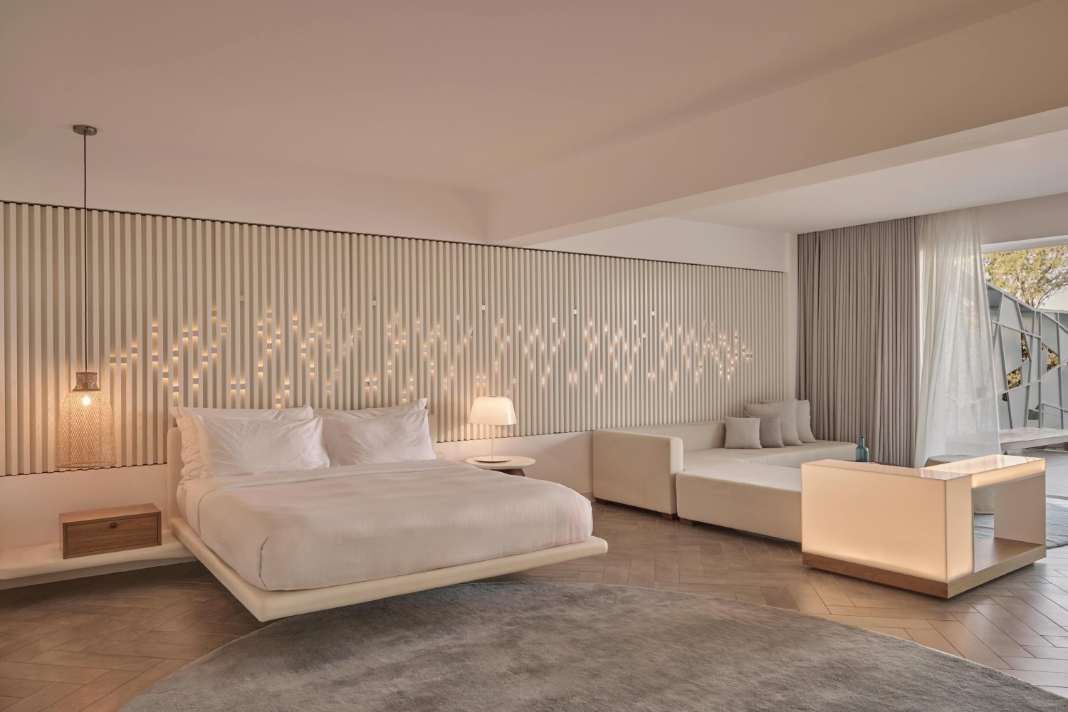 A luxurious hotel room featuring a king bed, stylish sofa, and elegant decor, perfect for relaxation and comfort
