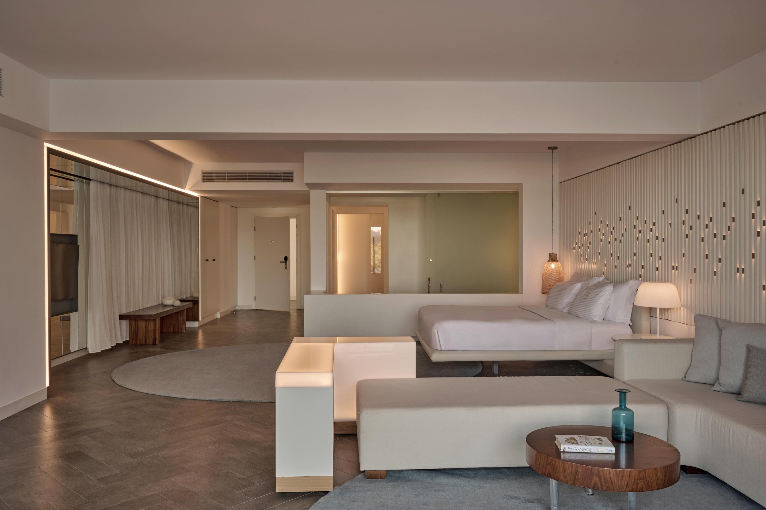 A luxurious hotel room featuring a king bed, stylish sofa, and a television, designed for ultimate comfort and relaxation