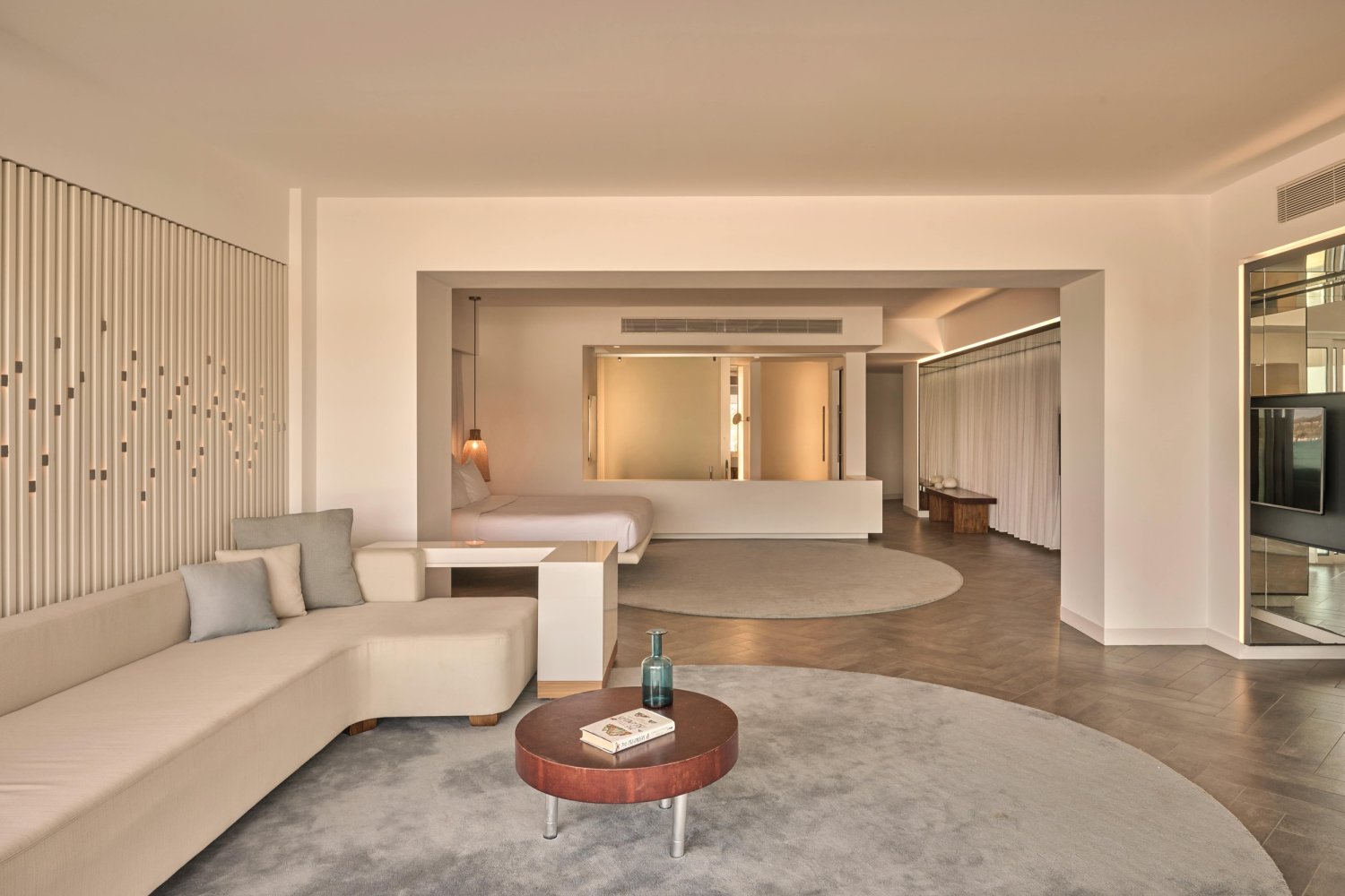 A luxurious hotel room featuring a modern round couch, designed for comfort and elegance with stunning sea views