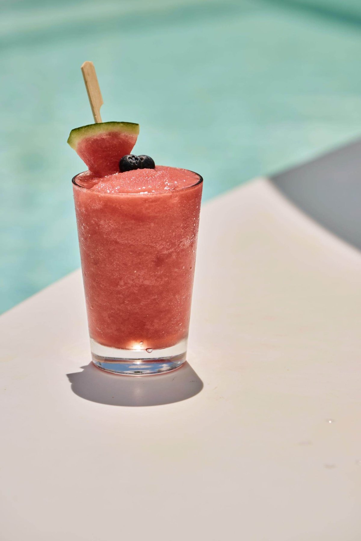 red Iced cocktail garnished with watermelon and berries