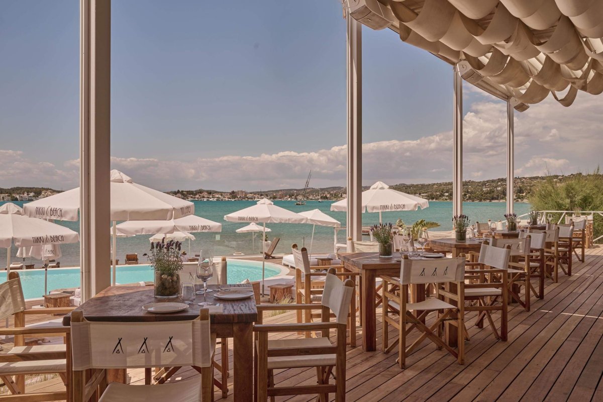 Dining area on decking next to the pool, looking out to the sea